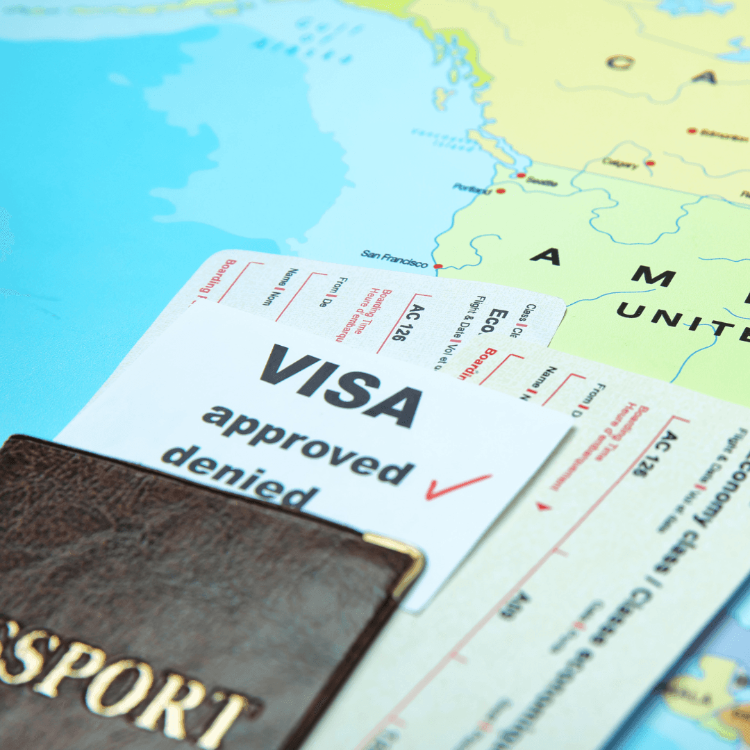 Close-up of a passport, a visa approval document, and boarding passes on a world map.